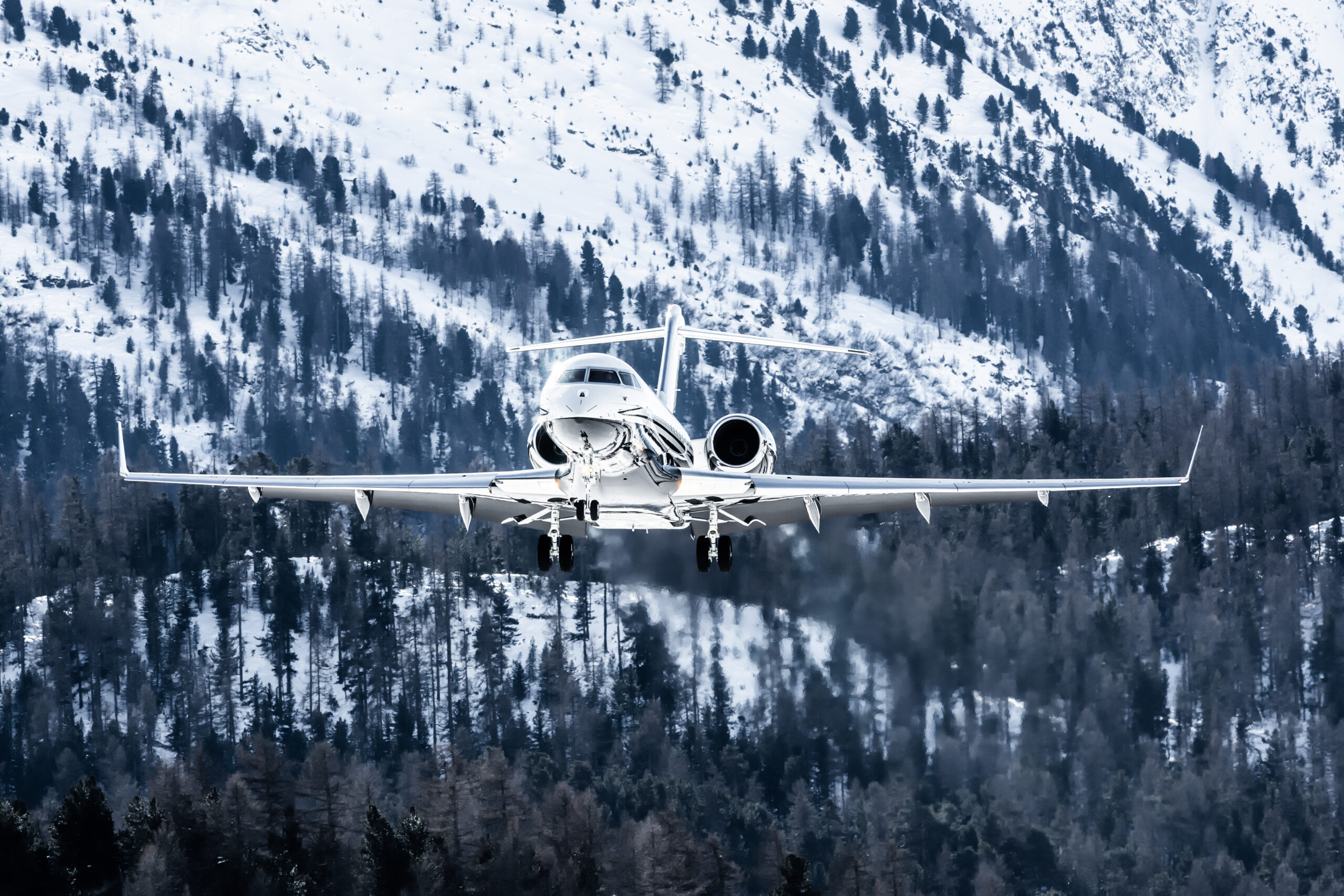 Jet privato Gulfstream in volo sopra montagne innevate vicino a Ginevra